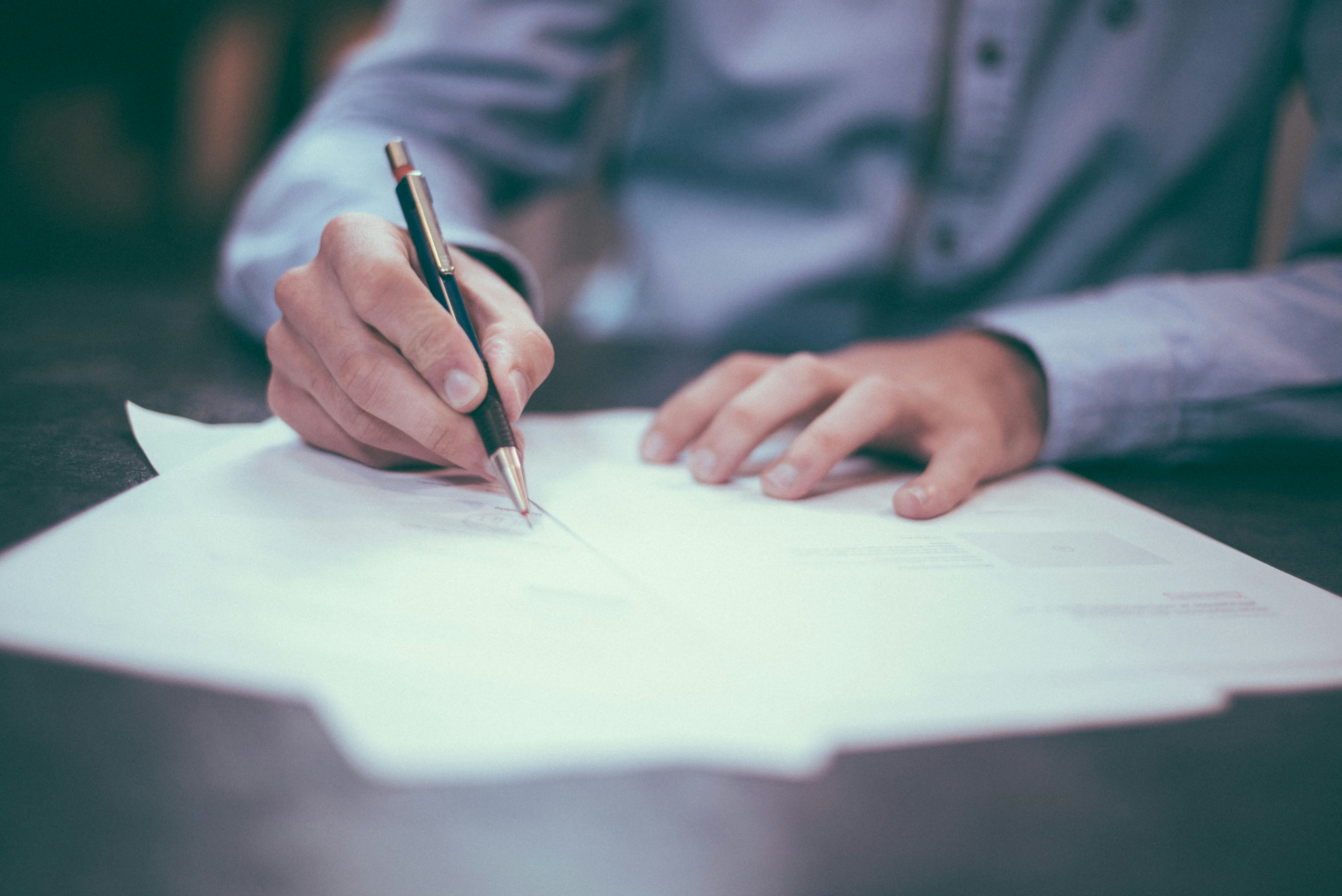 Close up of a person signing a document.